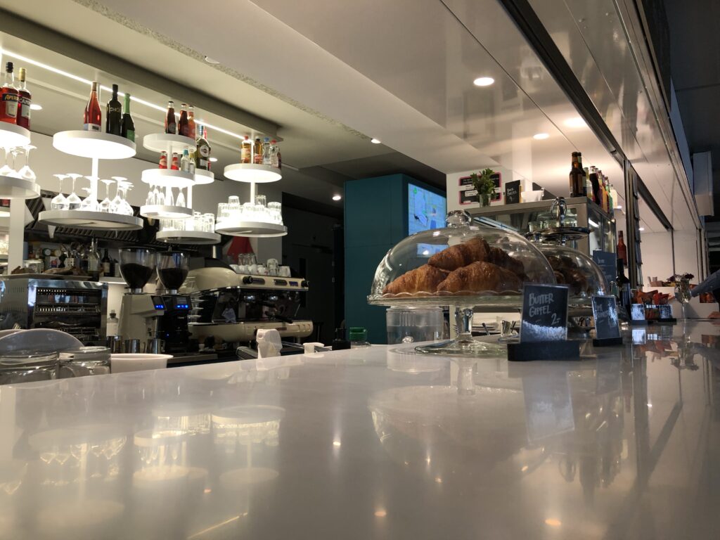 Nahaufnahme der Bar mit Gipfeli im Vordergrund und Getränken im Hintergrund.